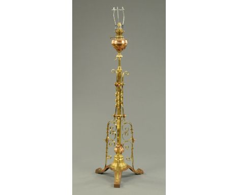 A Victorian brass and copper lamp standard, raised on three scroll feet.  