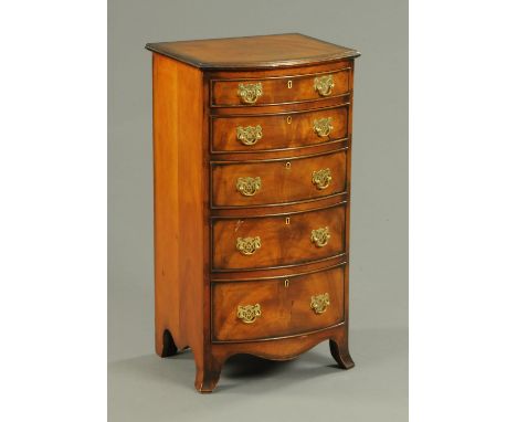 A reproduction walnut bowfronted chest of drawers, with moulded edge above five graduated drawers with brass swans neck drop 