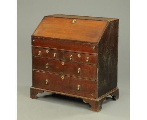 A George III oak bureau, with slope front to fitted interior with well and with two short and two long frieze drawers with br