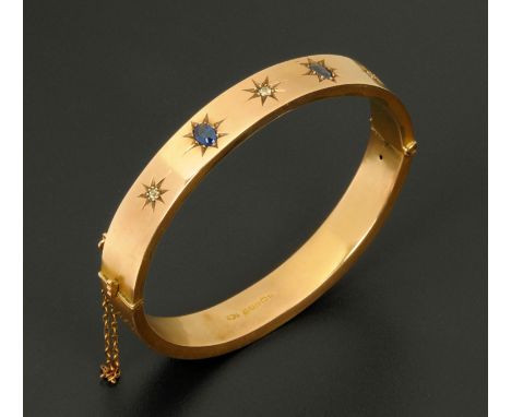 A 9 ct rose gold diamond and sapphire set bangle, 15 grams gross. 