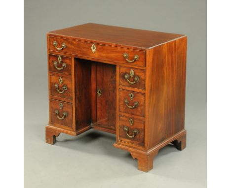 A George III mahogany kneehole desk, with recessed cupboard and series of drawers and all raised on bracket feet.  Width 84 c