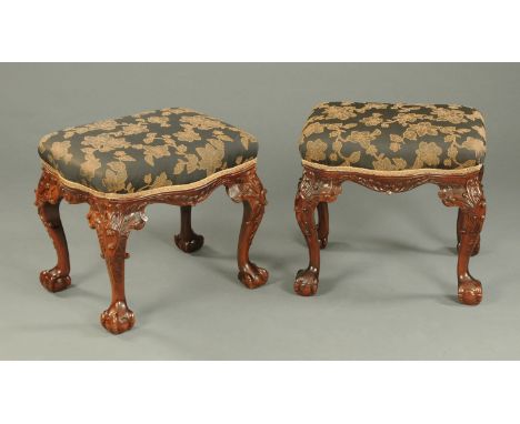 A pair of mahogany stools, each of serpentine outline and with foliate carved cabriole legs terminating in claw and ball feet