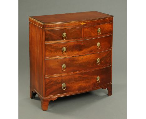 An early 19th century mahogany bowfronted chest of drawers, with two short and three long graduated drawers with brass drop h