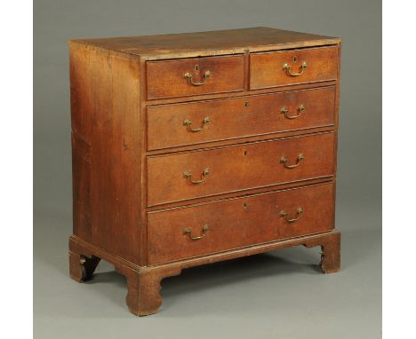 A Georgian oak chest of drawers, with two short and three long graduated drawers with brass drop handles and cockbeading to e