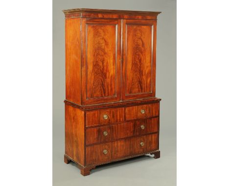 A George III mahogany linen press, with detachable moulded cornice above a pair of panelled cupboard doors enclosing hanging 