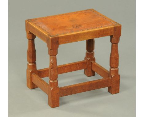 A Mouseman Thompson of Kilburn stool, with rectangular leather upholstered top.  Width 37.5 cm.  PROVENANCE - Purchased from 