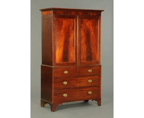 A George III mahogany gentleman's press, with moulded cornice above a pair of panelled cupboard doors enclosing hanging space