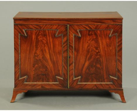 A Regency mahogany low cupboard, with moulded edge and crossbanded frieze above a pair of panelled doors with beaded moulding