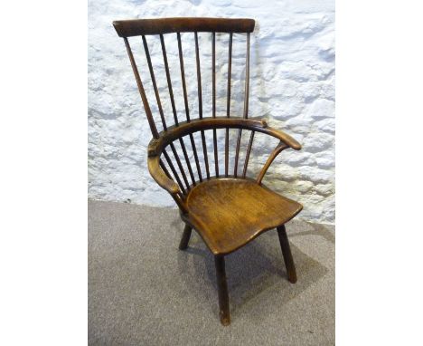 A Late 18th or Early 19th Century Elm Windsor Armchair, the stick back above shaped arms with a shaped seat raised upon turne