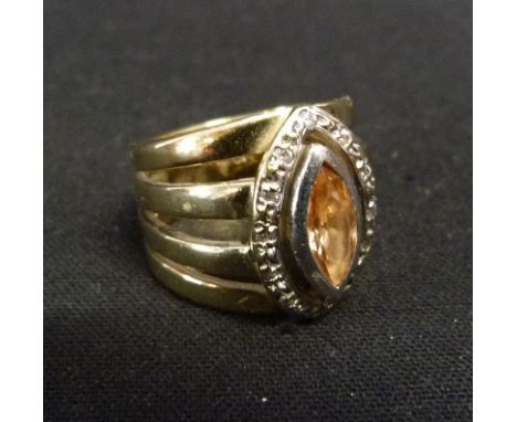 A 9ct. Gold Citrine and Diamond Ring, set with a marquise citrine surrounded by diamonds within four bands