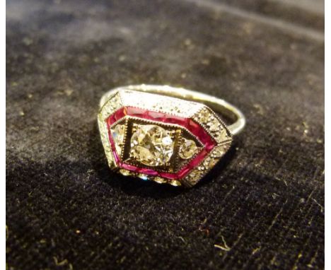 An 18ct White Gold Art Deco Style Ruby and Diamond Ring, set with a central diamond surrounded by a band of rubies and diamon