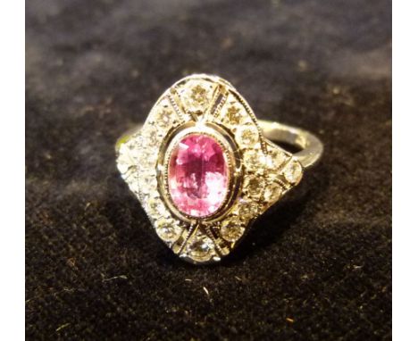 An 18ct White Gold Pink Sapphire and Diamond Ring with a central oval sapphire surrounded by diamonds within a pierced settin