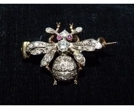 A Diamond and Ruby Set Brooch, in the form of a bee with a central diamond surrounded by diamonds and with ruby eyes set in y