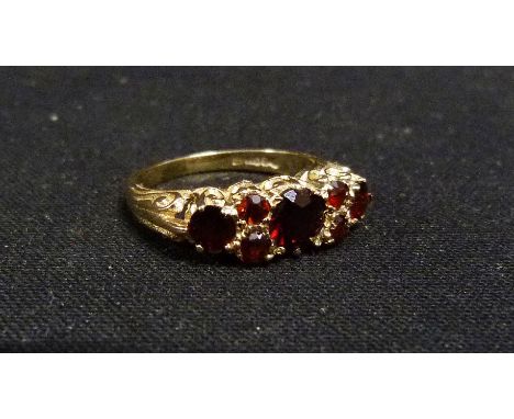 A 9ct. Gold Dress Ring set seven garnets within a pierced setting