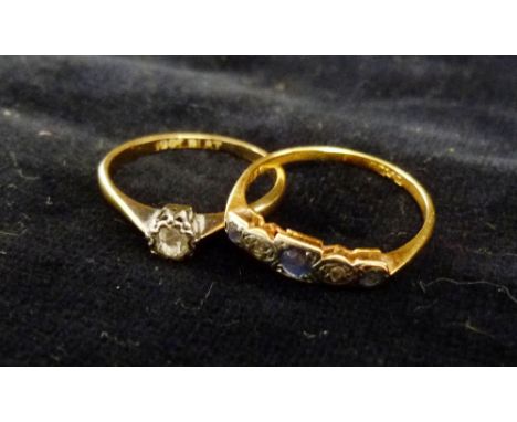 An 18ct. Gold and Platinum Solitaire Diamond Ring, claw set together with a gold diamond and sapphire ring set with three sap