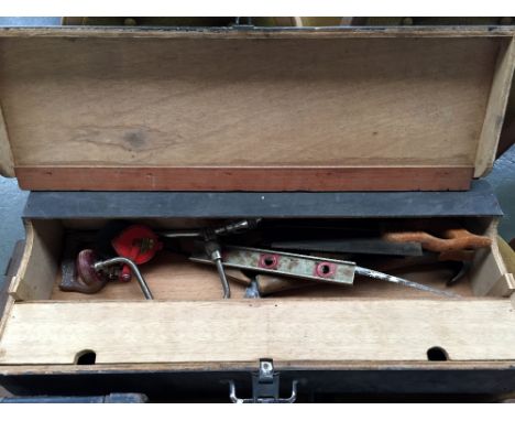 A wooden joiner's toolbox containing a quantity of English vintage tools such as chisels, hand-saw and other items