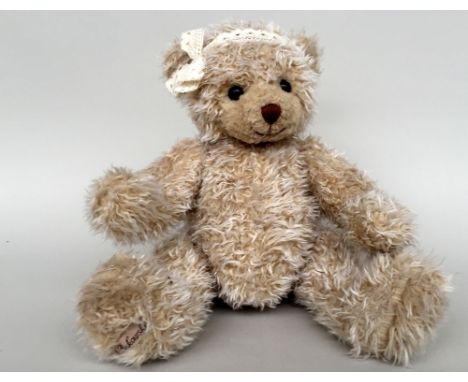 A Bukowski design teddy bear with articulated limbs and head, plastic black eyes, wearing a lace headband with a bow 42cmH