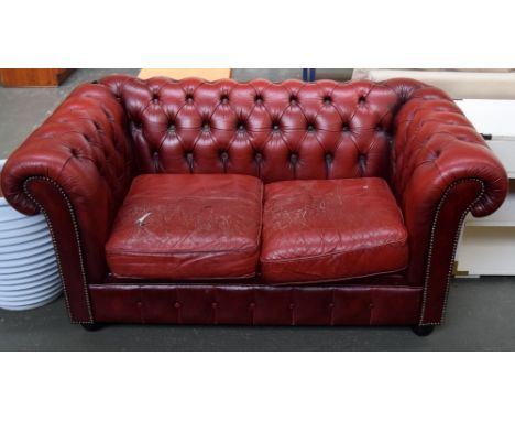 A red leather chesterfield style two seater sofa