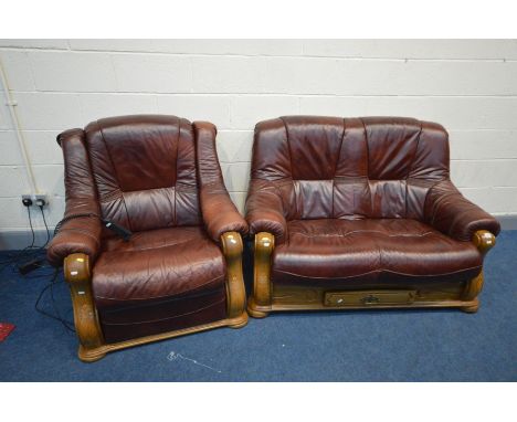 AN OAK FRAMED AND BURGANDY LEATHER TWO PIECE LOUNGE SUITE, comprising a sofa and an electric reclining armchair (PAT pass and