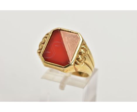 A GENT'S YELLOW METAL CARNELIAN SIGNET RING, rectangular shape with cut off corners, half set with a carnelian slice with the