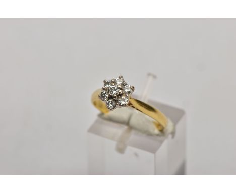 AN 18CT GOLD DIAMOND CLUSTER RING, slightly raised flower shape cluster with seven claw set round brilliant cut diamonds, tot