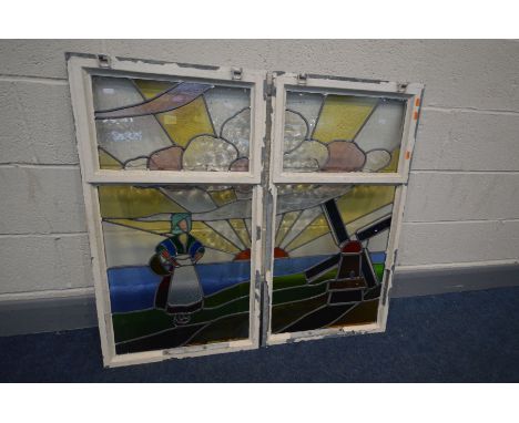 A PAIR OF EARLY 20TH CENTURY STAINED GLASS WINDOWS depicting a Dutch seascape with a windmill, standing female within a sunri