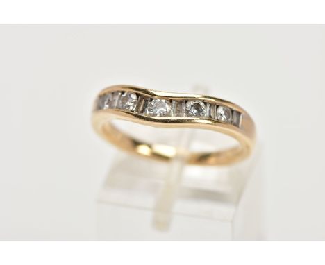 A YELLOW METAL DIAMOND HALF ETERNITY RING, of a wave design, channel set round brilliant cut diamonds interspaced with rectan