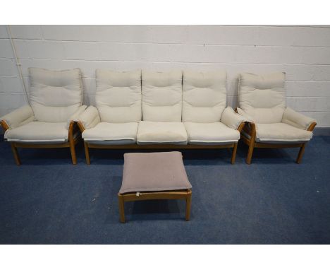 AN ERCOL GOLDEN DAWN ELM FOUR PIECE LOUNGE SUITE, comprising a three seater settee, pair of armchairs and a footstool with a 