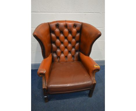 A BURNT ORANGE LEATHER BUTTON WINGBACK ARMCHAIR (condition - rip to left arm, crack to right arm, leather needs attention, la