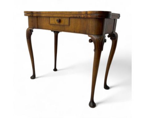 Edwardian mahogany fold-over card table, serpentine rectangular top opening to reveal a baize-lined surface, supported by a p