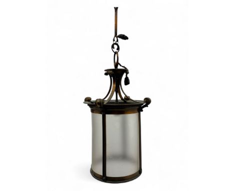 Early 20th century brass hanging lantern with frosted cylindrical glass, scrolling supports, and a coordinating brass ceiling