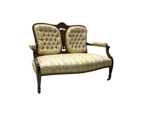 Edwardian rosewood two-seat settee, shaped back with inlaid decoration and carved crest, upholstered in striped fabric with c