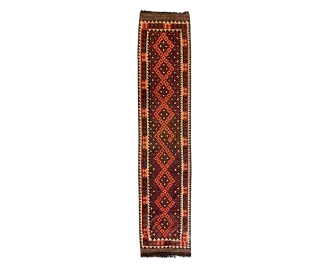 Handwoven Kilim ground runner, deep red ground with a repeating multicoloured diamond lattice pattern, framed by a bold geome