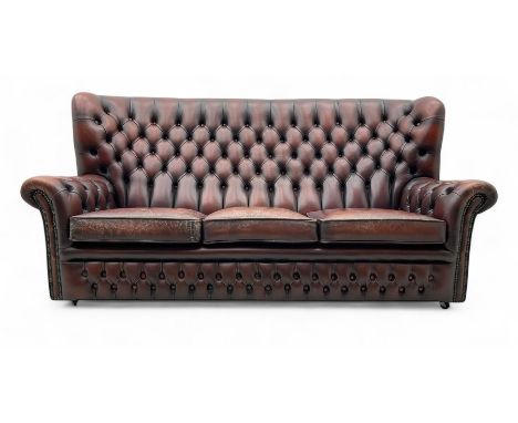 Georgian design buttoned oxblood leather three-seat sofa, deep-buttoned backrest, scrolled arms, and brass stud detailing, ra