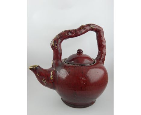 A large Japanese decorative ceramic tea pot with a sang de boeuf glaze, circa 1960, 36cm h, 37cm w.
