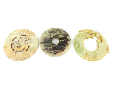 A carved celadon jade double dragon headed Huang, a ''neolithic'' cloud jade pi disc, and a jade pi disc centred with a drago