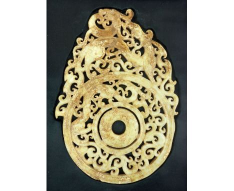 A fine Chinese Han style carved dragon pi roundel in pale green, white and ochre stained jade (carved both sides), 25 x 17cm,
