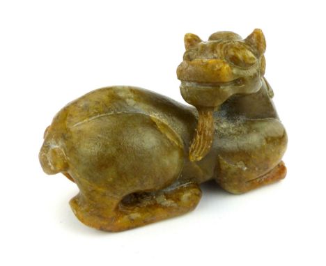 A Ming style carved olive green jade crouching mythical beast with beard and curling mane, 8 x 14cm.