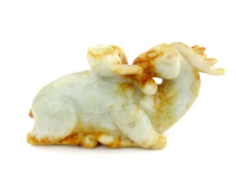 A Tang style carved jade crouching antelope turning to consume peaches, translucent white with ochre staining, 7 x 15cm.