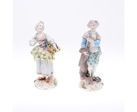 A pair of Meissen figures, including a lady holding a basket of fruit, and a gent with a snake and fish around the base. With
