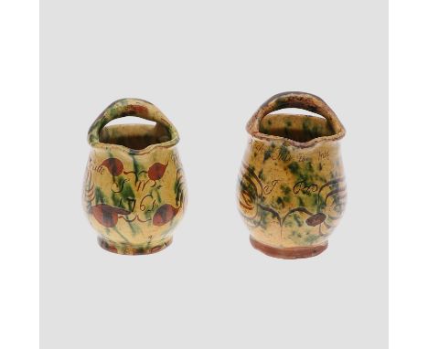 Probably by the Donyatt Pottery, the small pot with a handle to the rim and painted with flowers and leaves, inscribed 'S M 1