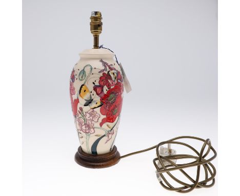 A large lamp painted with flowers and insects, mounted with a wooden base. Also with a light fitting and shade. 37cms high to