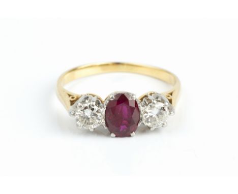 A RUBY AND DIAMOND THREE STONE RING, the oval mixed-cut ruby claw set between two round brilliant-cut diamonds, two colour pr