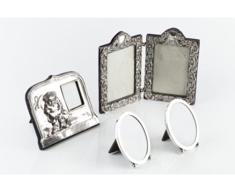 A LATE VICTORIAN SILVER MOUNTED RECTANGULAR DOUBLE PHOTO FRAME, the hinged frame pierce decorated and embossed with flowers a
