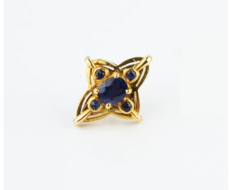 A SAPPHIRE SET TIE PIN, the quatrefoil-shaped panel centred with an oval mixed-cut sapphire in claw setting, bordered by four