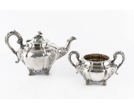 AN EARLY VICTORIAN IRISH SILVER TEAPOT, and matching twin handled sucrier, embossed and engraved with flowers, and with leaf 