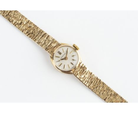A LADY'S 9CT GOLD BRACELET WATCH BY LONGINES, the circular silvered dial with baton markers, to a jewelled manual wind moveme