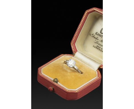 A DIAMOND SINGLE STONE RING, the cushion-shaped old-cut diamond claw set between baguette-cut diamond shoulders, white precio