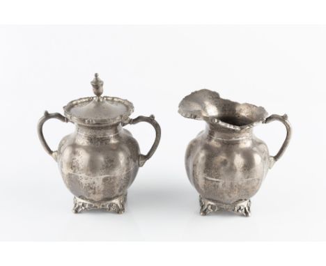 A MEXICAN SILVER TWIN HANDLED SUCRIER AND COVER, and matching milk jug, with shaped foliate cast borders and pierce decorated