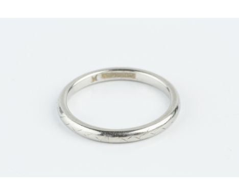 A WHITE METAL WEDDING BAND, with engraved decoration, stamped 'Platinum', ring size J½ Approx. gross weight only: 3.1gm